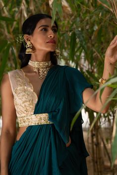 This stunning teal green ruffle saree in chiffon is paired with a silk organza embroidered blouse with mirror, pechani, zardosi, resham, pearl and sequins work. The blouse has an attached embroidered blouse. Green Cutdana Pre-draped Saree For Evening, Green Embellished Anarkali Pre-draped Saree, Transitional Pre-draped Saree With Mirror Work For Party, Transitional Party Pre-draped Saree With Mirror Work, Green Georgette Blouse With Mirror Work, Green Blouse Piece With Dupatta For Evening, Green Georgette Pre-draped Saree For Transitional Season, Chinon Pre-draped Saree For Reception In Transitional Season, Chinon Pre-draped Saree For Reception And Transitional Season