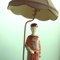 a figurine holding a lamp on top of a table