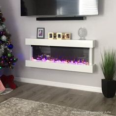 a living room with a christmas tree and a flat screen tv mounted on the wall