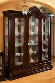 the china cabinet has many glass doors and drawers on it's sides, as well as