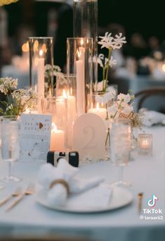 the table is set with candles, plates and napkins for an elegant wedding reception