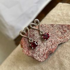 "Natural Red Garnet Earrings - Sterling Silver Earrings - Red Garnet Dangle Earrings: These sterling silver dangle earrings feature natural Red Garnet stones. The Red Garnet stones are both 6mm (1/4\") in diameter and weigh 1.7 ct.. The included, large sterling silver backs are 9mm (3/8\") in diameter. The settings are 18mm (3/4\") long, from the top of the hearts to the bottom of stones. The silver cut-out hearts on the posts add to the fanciful feeling of these earrings. They compliment the go Red Garnet Earrings, Silver Heart Earrings, Silver Lace, Garnet Pendant, Red Gemstones, Garnet Earrings, Silver Dangle Earrings, Garnet Stone, Earrings Red