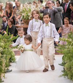 two young children are walking down the aisle