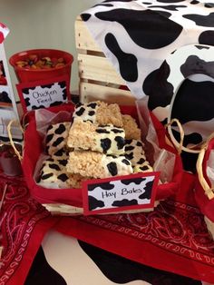 a cow themed birthday party with desserts and treats on the table, including rice krispy bars