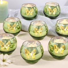 green glass candles with yellow butterflies on them