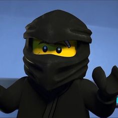 the lego ninja is wearing a black mask and holding his hands up in front of him