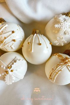 white and gold christmas ornaments on a white cloth