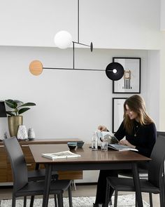 a woman sitting at a table reading a book in a room with black and white decor