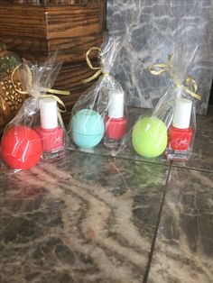 four small bottles filled with different colored nail polishes on top of a marble counter