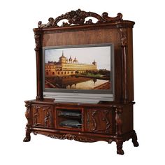 an ornate wooden entertainment center with a painting on it