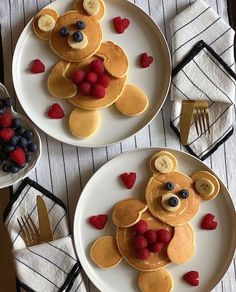 two white plates topped with pancakes covered in fruit and teddy bear shaped toppings,