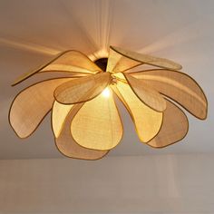 a ceiling light with a flower design hanging from it's center point in a room