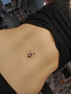 a woman's stomach with two piercings on the bottom and one in the middle