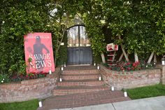 an entrance to a building with brick steps and plants growing on the sides, along with a sign that says vaggie news