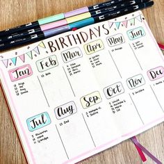 a birthday planner with markers and pencils next to it on a wooden table top