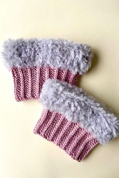 two knitted mittens sitting next to each other on top of a white surface