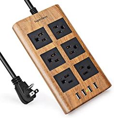 the wooden power strip is plugged in and has four surge protectors attached to it