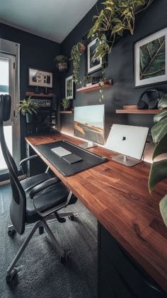 a home office with black walls, wooden desk and plants on the shelves above it