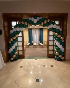 an archway decorated with balloons and streamers in the middle of a floored room