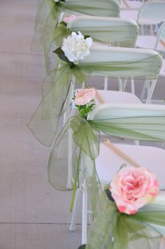 rows of white chairs with green sashes and pink flowers