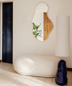 a living room with a large mirror on the wall and a white couch in front of it