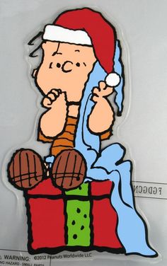 a charlie brown christmas sticker sitting on top of a box with a santa hat