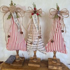 three christmas trees made out of old sheet music and burlocks with ribbons on them