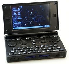 an open laptop computer sitting on top of a white table next to a game controller