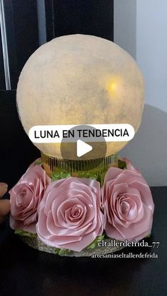 there is a vase with pink roses on it and a light in the middle that says luna en tendendcia