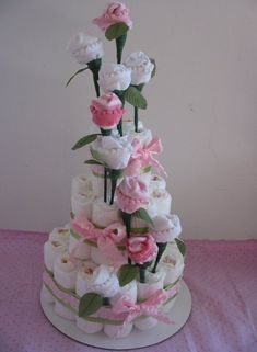 a wedding cake with pink and white flowers on it's tiered display stand