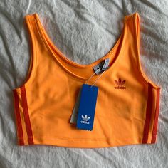 Adidas Neon Crop Top Never Worn Color Neon Orange Perfect Condition Will Steam Before Shipping Adidas Fitted Sleeveless Tank Top, Adidas Sleeveless Fitted Tank Top, Fitted Sleeveless Adidas Tank Top, Summer Sports Tops With Three Stripes, Orange Sleeveless Top For Athleisure, Orange Sleeveless Athleisure Top, Orange Sports Tops For Summer, Adidas Casual Tank Top For Sports, Trendy Orange Sports Top