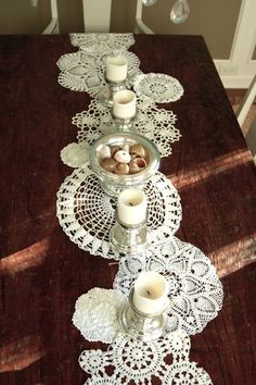 a long table with candles and doily on it