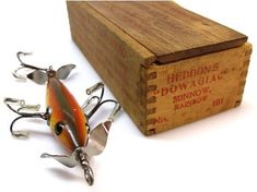 a wooden box with some fishing lures in it