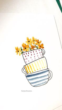 some yellow flowers are in a blue and white cup