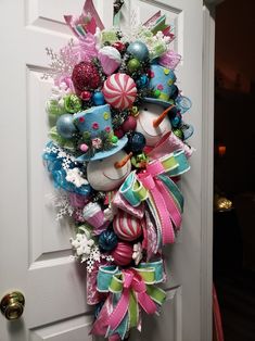 a christmas wreath hanging on the front door with candy and candies around it's edges