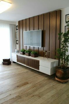 a living room with wood paneling and a flat screen tv mounted on the wall