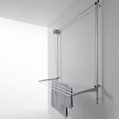 a towel rack in the corner of a room with white walls and metal bars on it