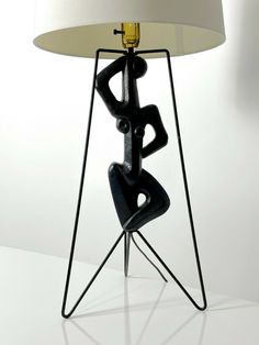 a lamp that is sitting on top of a white table next to a black chair