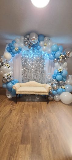 a room filled with balloons and decorations on the wall next to a couch in front of a window