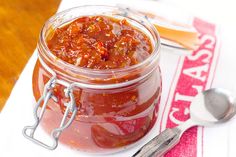 a glass jar filled with sauce on top of a table