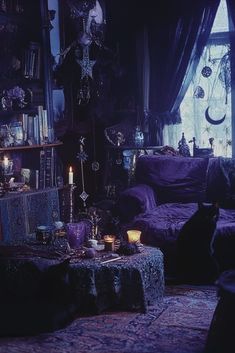 a living room filled with purple furniture and lots of candles on the coffee table in front of a window