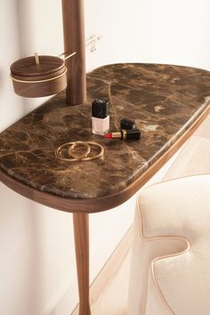 a marble top table with lipstick, nail polish and other items on it in front of a mirror