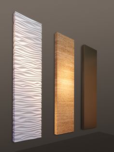 three wall sconces mounted to the side of a wall next to a lamp