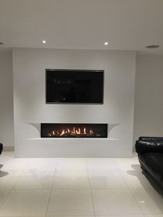 a living room with a fireplace and two black couches