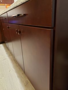 a kitchen with brown cabinets and white counter tops