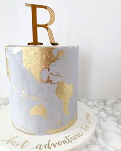 a white and gold cake with the letter r on top