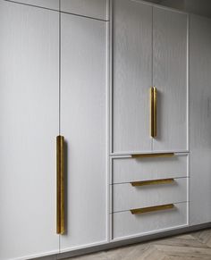 a white cabinet with gold handles and drawers