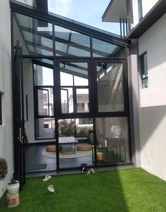 the inside of a house with grass in front of it and an open glass door