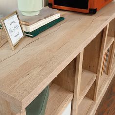 a wooden shelf with books and a radio on top, next to an orange speaker