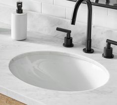 a bathroom sink with two faucets and soap dispensers on the counter